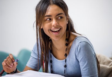 Humanities student laughing at a comment in a lecture