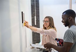 Students securing a frame to a gallery wall