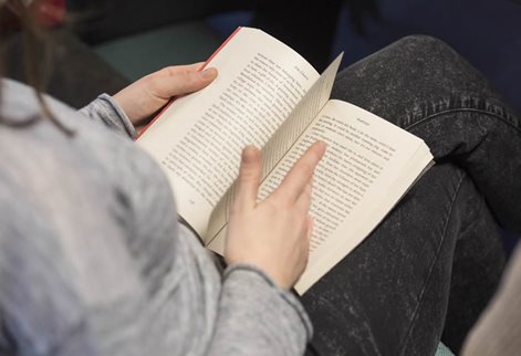 Student reading from a literature book