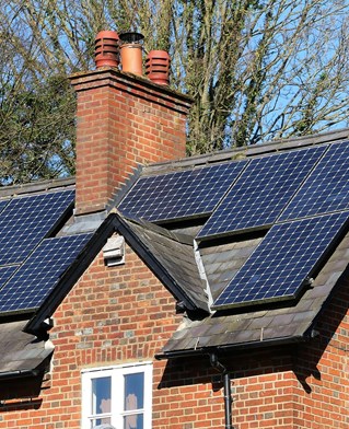 Red brick house with solar panels on the roof.