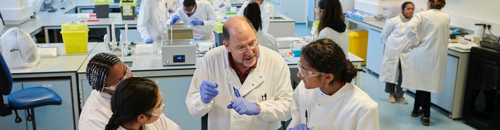 Lecturer talking to biomedical students in lab