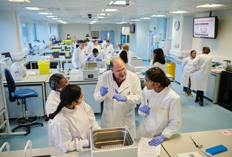Lecturer talking to biomedical students in lab