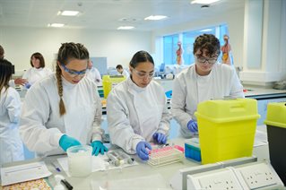 Three biomedical students in specialist lab with plasma samples