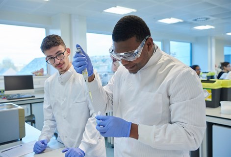 Students in white coats in labs