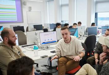 Group of students  discussing work in a computer room