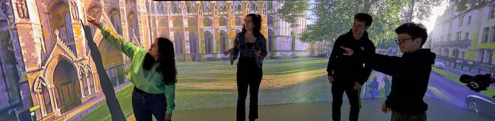 Group of students looking at an image of buildings on a curved 360 screen