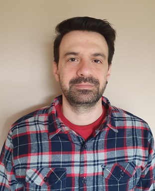 Headshot of Anestis Touloumis looking at the camera wearing a checked shirt