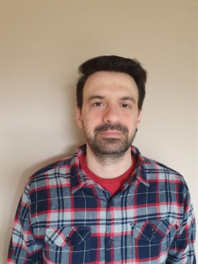 Headshot of Anestis Touloumis looking at the camera wearing a checked shirt