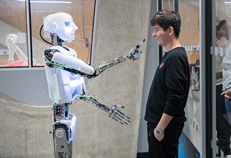 Student looking at a robot in the robotics lab