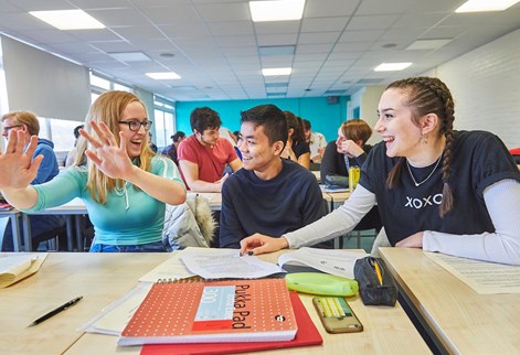 Three maths students smiling and talking together