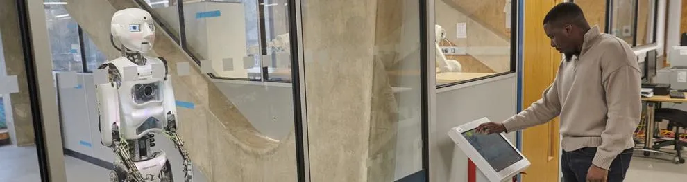 Student programming a humanoid robot in a lab