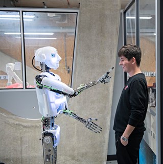 Robot with arms out to a student