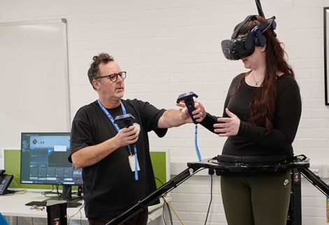 Student using VR headset with technician helping