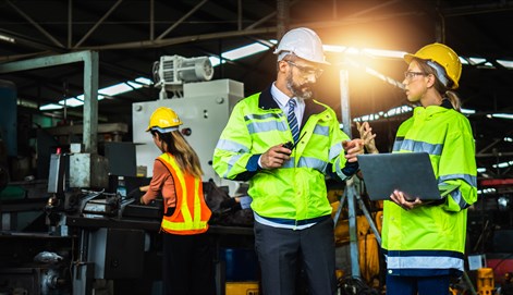 Student and employer in factory wearing safety wear