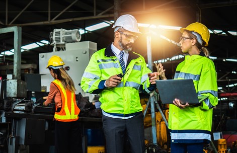 Student in a industry setting with male figure wearing safety wear