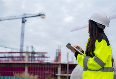 Site supervisor looking at cranes in distance