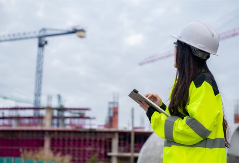 Site supervisor looking at cranes in distance