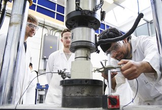 Students working with civil engineering facility for testing concrete