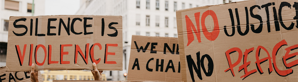 Close up of placards from a demonstration including: Silence is violence