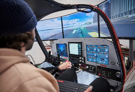 Looking over a students shoulder working in the engineering flight simulator