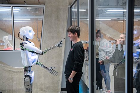 Student standing in front of humanoid