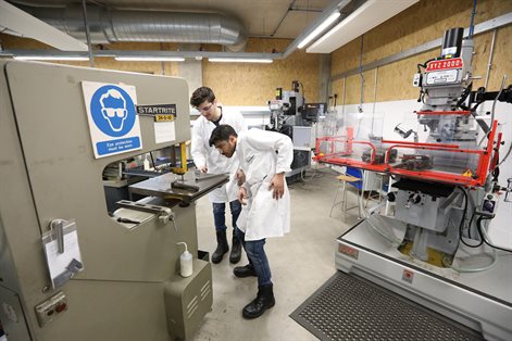 Two students using machine in advanced engineering building