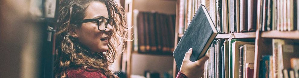 woman in library looking at book