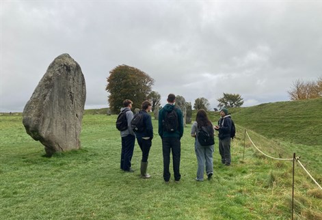 Dr Chris Carey with four students in front of stone circle