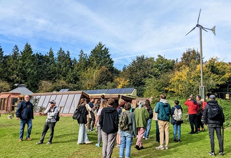 Group of students in a park by a low level building