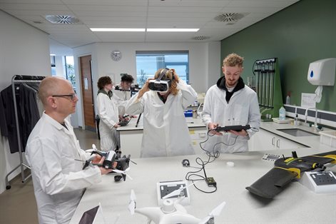 Students and techician using drone equipment in the lab