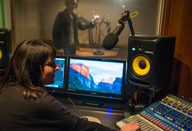 Two people in a studio making an audio recording