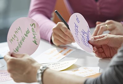 Two people looking at words on post-it notes