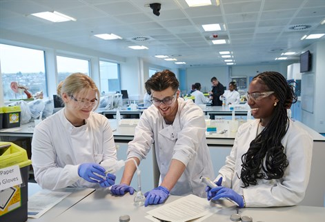 Three pharmacy students conducting an experiment in lab