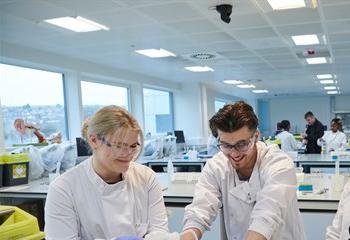 Three pharmacy students conducting an experiment in lab