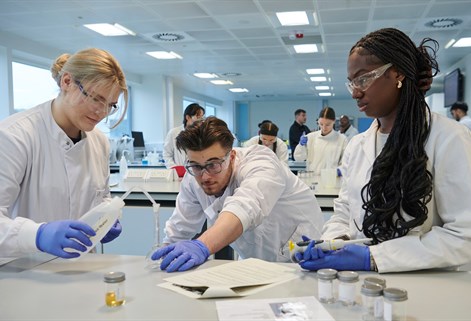 Three students in lab using equipment