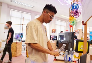 A product design student with their work