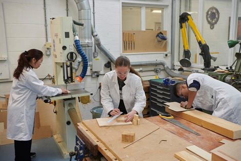 Three product design students working in workshop