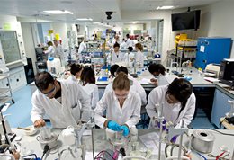 Students in white lab coats in a Biology lab