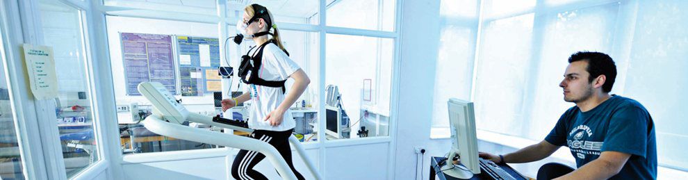 Student on treadmill with sensory recording equipment attached being supervised.