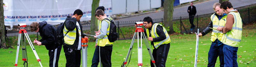 Construction students using equipment to survey a field