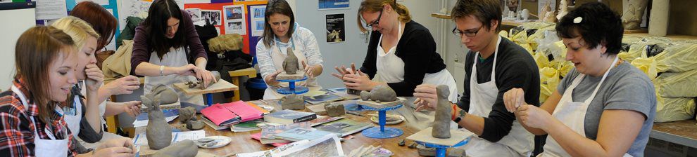 Image illustrating occupational therapy, showing a group making clay models around a large work table