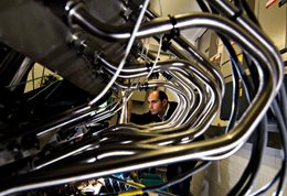Photograph of engine pipes with researcher in background