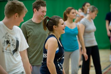 A group of people in a sports hall laughing