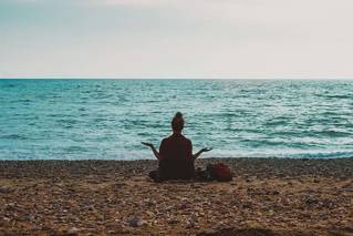 Silhouette of student on Brighton beach looking out to sea