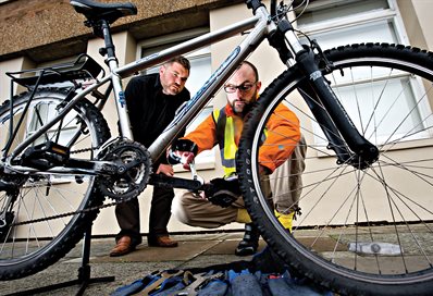 Dr Bike looking at a bicycle, with owner watching