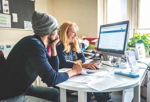 Two people looking at a computer