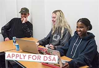 Three students at a table with laptops