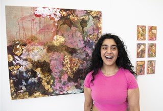 Student in front of their artwork