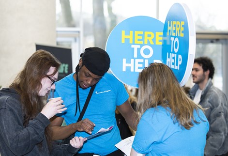 Student ambassadors with signs: Here to help
