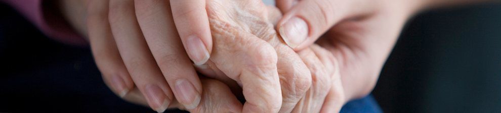 Close up of younger hands holding older hands